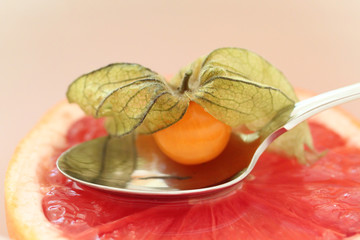Saftige Grapefruit-Hälfte mit Löffel und Karambole