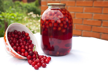 Fresh cherries and a jar of jerry juice on a garden table