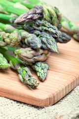 Fresh green asparagus on cutting board, closeup shot