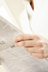 Naklejka premium 新聞を読むビジネスレディの手