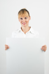 Happy smiling young business woman showing blank signboard