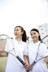 ラケットを持つ笑顔の女子高校生