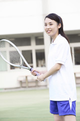 テニスラケットを持った女子高校生