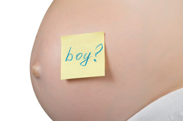 Pregnant woman with a sticky note saying Boy on her belly.