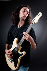 Obraz premium Guitar player against the dark background