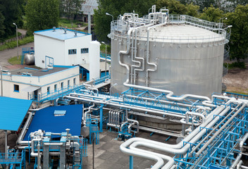 Silver industrial oil container with stairs in a refinery