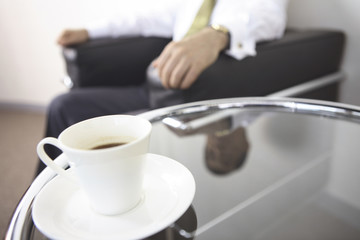 コーヒーとソファに座る社長