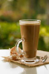 coffee latte in palm tree and sunset background, warm light
