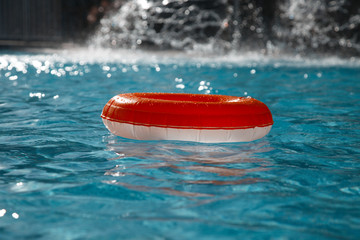 floating  ring on blue water swimpool with waves reflecting in t