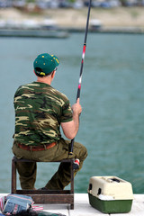 Pescatore sulla sedia con la canna