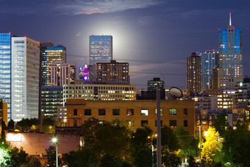 Glowing Moon Rises Behind The Denver CO Skyline
