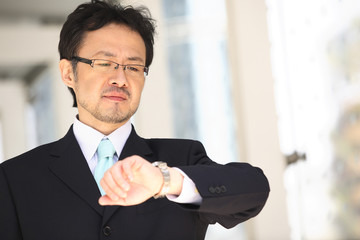 腕時計を見るビジネスマン