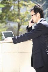 携帯電話で話すビジネスマン