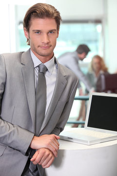 Smart young salesman with laptop computer