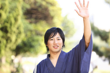 手を振る浴衣男性
