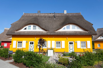 Fototapeta na wymiar Dwa strzechą dom z rze¼bami w drzwiach