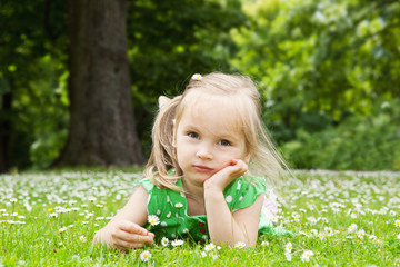 Beautiful little girl relaxing on a meadow