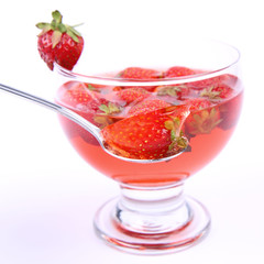 Jelly with strawberries being eaten with a spoon