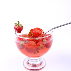 Jelly with strawberries being eaten with a spoon