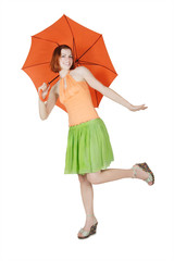 young girl in bright clothes standing on one leg with umbrella,