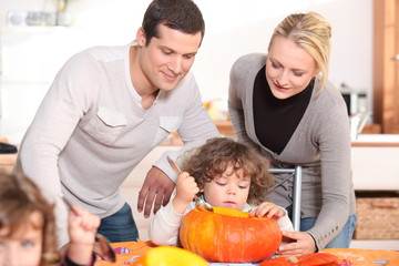 Fototapeta na wymiar Family carving a pumpkin