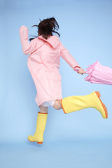 雨具を着てジャンプする女性