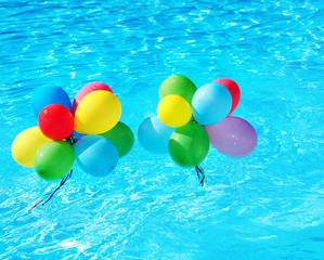 Balloons floating in swimming pool.