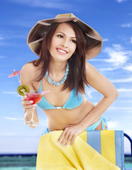 Girl in bikini drinking cocktail.