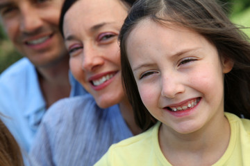 Obraz premium Portrait of smiling little girl with parents in background