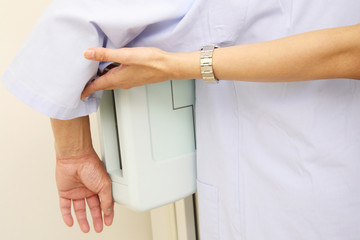 レントゲンをとる患者の腕を支える女性技師