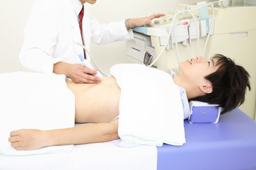 エコーで腹部を検査する男性患者