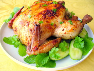 Roasted whole chicken on a plate with vegetables