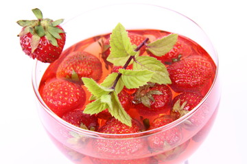 Jelly with strawberries decorated with a mint twig in a cup