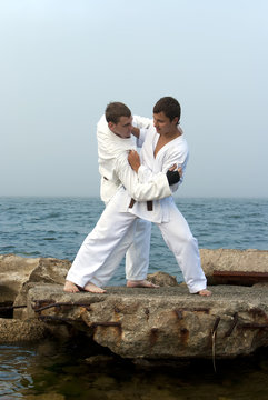 two karateka fight on the banks of the misty sea