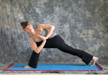 woman doing Yoga posture Parivrtta Parsvakonasana or Revolved Ex