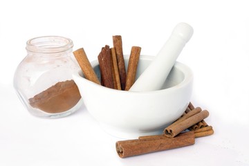 grinding cinnamon into powder in porcelain montar