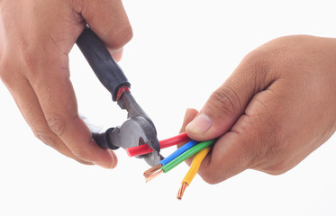 man's hand hold wire cutter to strip electrical wire while holdi
