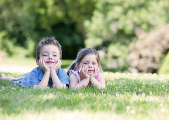 Siblings laying on the grass