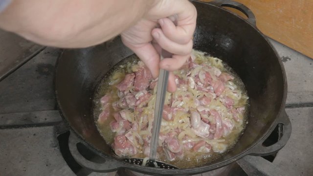 EDIT Turning with slotted spoon slices of pork and onions