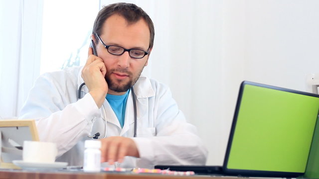 Doctor talking on mobile phone in the office
