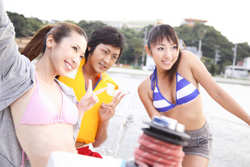 ヨット上で記念撮影をする若者