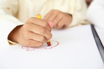 クレヨンで絵を描く子供の手元