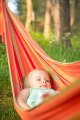 Adorable baby girl relaxing in hammock