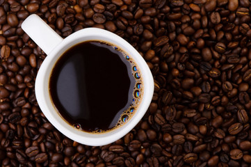 Cup of coffee on coffee beans.
