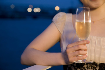 テラスでシャンパンを飲む女性の手元