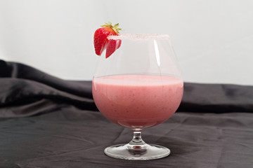 a strawberry milk shake against black background