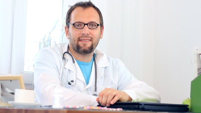 Portrait of male doctor working on laptop