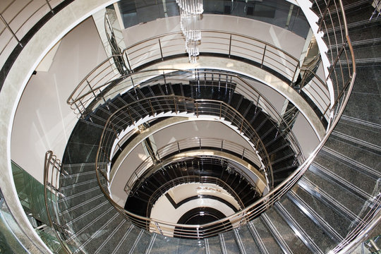 Spiral staircase made by grey marble and chrome railing