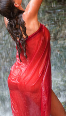 Girl in red under waterfall