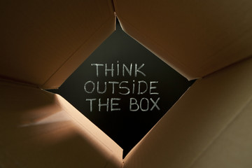 Think Outside The Box Cardboard Concept on Blackboard